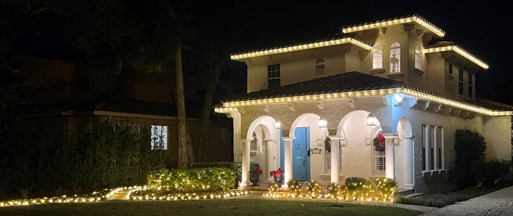 Two story install with soft white double roofline lighting and landscape ground lighting